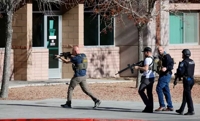 FILE - Law enforcement officers head into the University of Nevada, Las Vegas, campus after reports of an active shooter, Wednesday, Dec. 6, 2023, in Las Vegas. (Steve Marcus/Las Vegas Sun via AP, File)