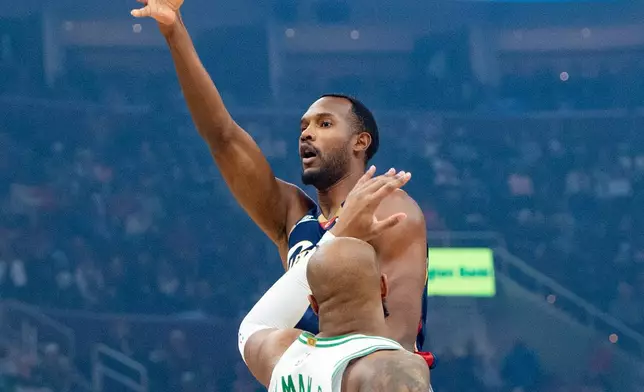 Cleveland Cavaliers' Evan Mobley, rear, shoots over Boston Celtics' Xavier Tillman (26) during the first half of an NBA basketball game in Cleveland, Sunday, Nov. 30, 2025. (AP Photo/Phil Long)