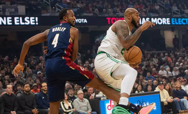 Boston Celtics' Xavier Tillman, left, secures a rebound in front of Cleveland Cavaliers' Evan Mobley during the first half of an NBA basketball game in Cleveland, Sunday, Nov. 30, 2025. (AP Photo/Phil Long)