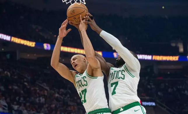 Boston Celtics' Jordan Walsh (27) and Jaylen Brown (7) try for a rebound against the Cleveland Cavaliers during the first half of an NBA basketball game in Cleveland, Sunday, Nov. 30, 2025. (AP Photo/Phil Long)