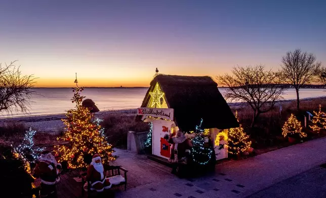 FILE - Christmas trees and Santa Clauses decorate the entrance to the beach in Haffkrug, northern Germany, Monday, Dec. 20, 2021. (Photo/Michael Probst, File)