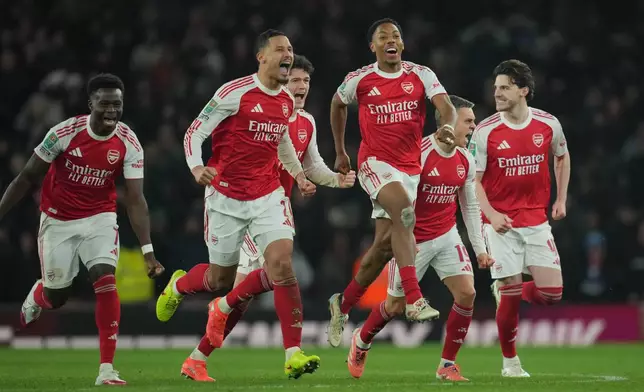 Arsenal players celebrate after winning in a penalty shootout the English Football League Cup quarter-final soccer match between Arsenal and Crystal Palace in London, Tuesday, Dec. 23, 2025. (AP Photo/Kin Cheung)
