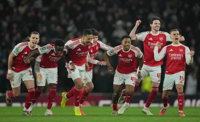 Arsenal players celebrate after winning in a penalty shootout the English Football League Cup quarter-final soccer match between Arsenal and Crystal Palace in London, Tuesday, Dec. 23, 2025. (AP Photo/Kin Cheung)