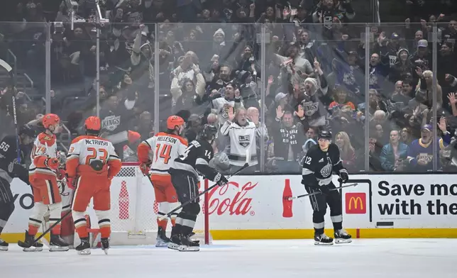 Los Angeles Kings left wing Trevor Moore (12) skates after scoring a goal as Los Angeles Kings right wing Alex Laferriere (14), left, follows during the first period of an NHL hockey game against the Anaheim Ducks, Saturday, Dec. 27, 2025, in Los Angeles. (AP Photo/Katie Chin)