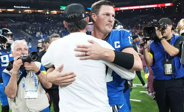 San Francisco 49ers head coach Kyle Shanahan, middle left, hugs Indianapolis Colts quarterback Philip Rivers after an NFL football game, Monday, Dec. 22, 2025, in Indianapolis. (AP Photo/AJ Mast)