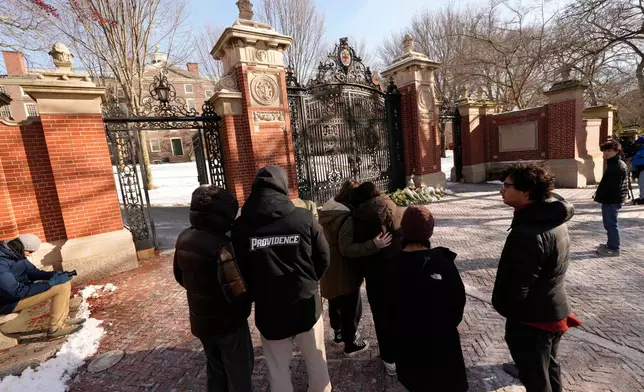 People gather at near makeshift memorial on the campus of Brown University, not far from the scene of the shooting, Monday, Dec. 15, 2025, in Providence, R.I. (AP Photo/Robert F. Bukaty)