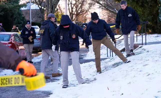 Members of the FBI Evidence Response Team search for evidence near the campus of Brown University, Monday, Dec. 15, 2025, in Providence, R.I. (AP Photo/Robert F. Bukaty)