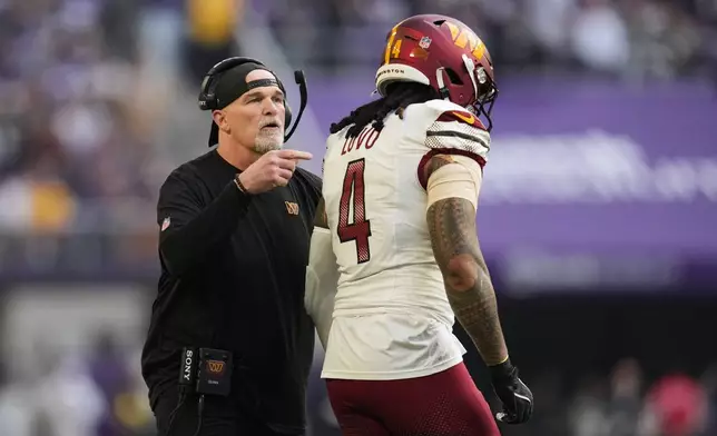 Washington Commanders head coach Dan Quinn talks to linebacker Frankie Luvu (4) on the sideline during the first half of an NFL football game against the Minnesota Vikings, Sunday, Dec. 7, 2025, in Minneapolis. (AP Photo/Abbie Parr)