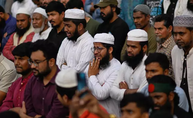 People react as they gather to perform funeral prayers for leading Bangladeshi activist Sharif Osman Hadi, who died from gunshot wounds sustained in an attack in Dhaka earlier this month, outside the nation's Parliament complex in Dhaka, Bangladesh, Saturday, Dec. 20, 2025. (AP Photo/Mahmud Hossain Opu)