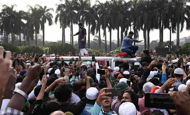 People gather around an ambulance carrying the body of leading Bangladeshi activist Sharif Osman Hadi, who died from gunshot wounds sustained in an attack in Dhaka earlier this month, following his funeral prayers outside the nation's Parliament complex in Dhaka, Bangladesh, Saturday, Dec. 20, 2025. (AP Photo/Mahmud Hossain Opu)