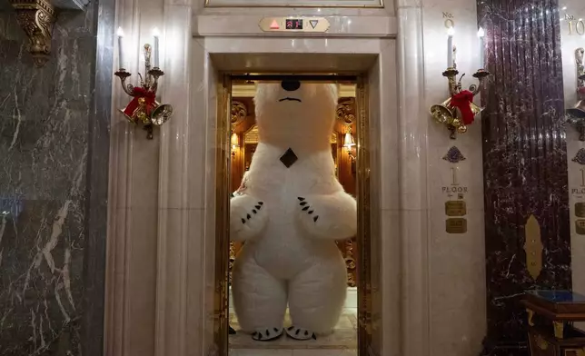 A polar bear mascot takes a ride in a lift during a break from entertaining guests on the eve of Christmas in Beijing, Wednesday, Dec. 24, 2025. (AP Photo/Ng Han Guan)