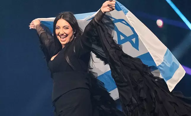 FILE - Singer Yuval Raphael, from Israel, holds the national flag during a dress rehearsal for the Grand Final of the 69th Eurovision Song Contest, May 16, 2025, in Basel, Switzerland. (AP Photo/Martin Meissner, File)