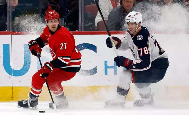 Carolina Hurricanes' Nikolaj Ehlers (27) controls the puck in front of Columbus Blue Jackets' Damon Severson (78) during the third period of an NHL hockey game in Raleigh, N.C., Tuesday, Dec. 9, 2025. (AP Photo/Karl DeBlaker)