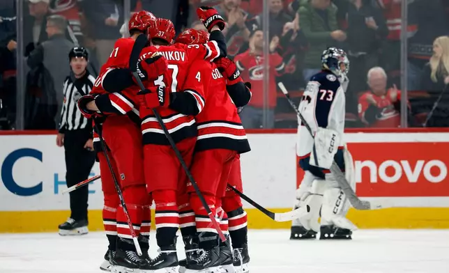 The Carolina Hurricanes celebrate a goal by Jordan Staal (11) as Columbus Blue Jackets goaltender Jet Greaves (73) skates back to the net during the third period of an NHL hockey game in Raleigh, N.C., Tuesday, Dec. 9, 2025. (AP Photo/Karl DeBlaker)