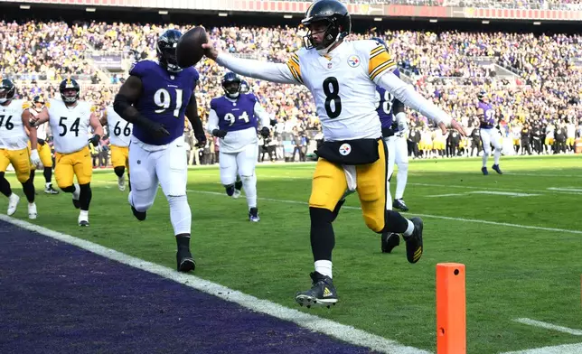 Pittsburgh Steelers quarterback Aaron Rodgers (8) runs to the end zone for a touchdown during the first half of an NFL football game against the Baltimore Ravens, Sunday, Dec. 7, 2025, in Baltimore. (AP Photo/Nick Wass)
