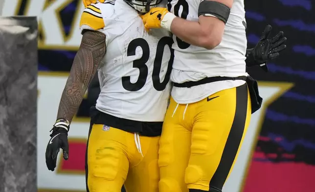 Pittsburgh Steelers running back Jaylen Warren (30) celebrates with quarterback Aaron Rodgers (8) after a touchdown during the second half of an NFL football game against the Baltimore Ravens, Sunday, Dec. 7, 2025, in Baltimore. (AP Photo/Stephanie Scarbrough)