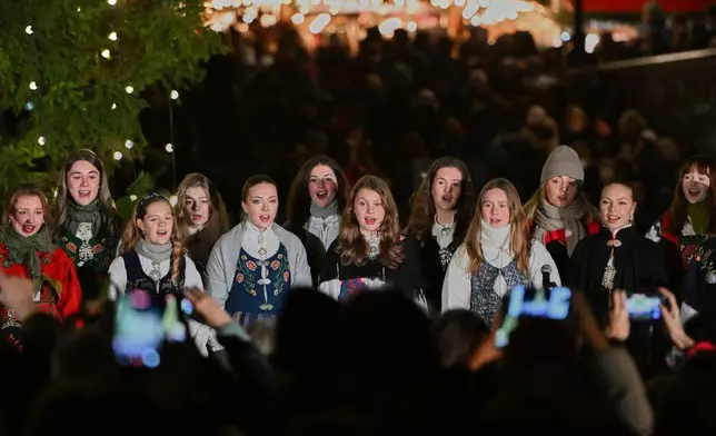 The traditional lighting up ceremony starts, with a choir singing carols, for the annual Norwegian gifted Christmas tree in Trafalgar Square, in London, England, Thursday, Dec. 4, 2025. (AP Photo/Thomas Krych)