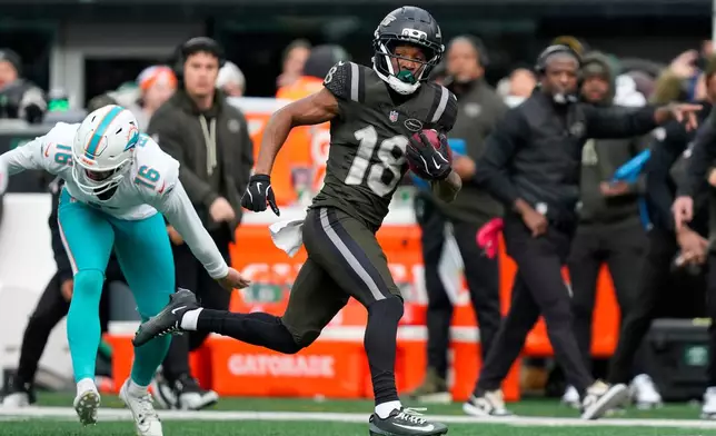 New York Jets wide receiver Isaiah Williams (18) returns a punt for a touchdown against the Miami Dolphins during the first quarter of an NFL football game, Sunday, Dec. 7, 2025, in East Rutherford, N.J. (AP Photo/Yuki Iwamura)