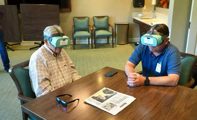 Jim Holtshouse and his son, Mike Holtshouse, watch video through Rendever virtual-reality headsets at the Forum at Rancho San Antonio retirement community in Cupertino, Calif. on June 11, 2025. (AP Photo/Terry Chea)