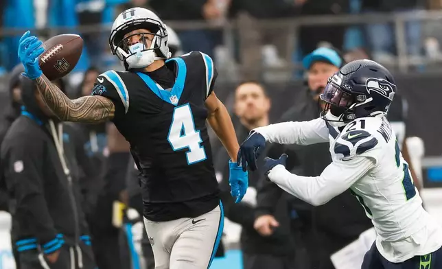 Seattle Seahawks cornerback Devon Witherspoon breaks up a pass intended for Carolina Panthers wide receiver Tetairoa McMillan during the first half of an NFL football game, Sunday, Dec. 28, 2025, in Charlotte, N.C. (AP Photo/Rusty Jones)
