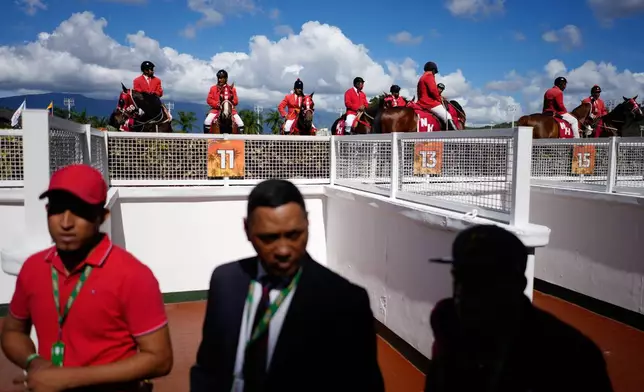 Judges wait between races during the 56th Jockey Challenge at the Rinconada racetrack in Caracas, Venezuela, Sunday, Dec. 14, 2025. (AP Photo/Arian Cubillos)