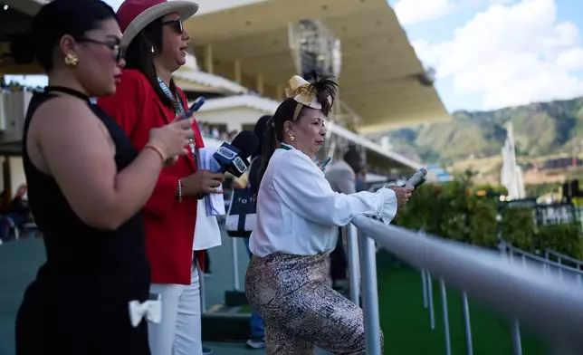 Spectators attend the 56th Jockey Challenge at the Rinconada racetrack in Caracas, Venezuela, Sunday, Dec. 14, 2025. (AP Photo/Arian Cubillos)