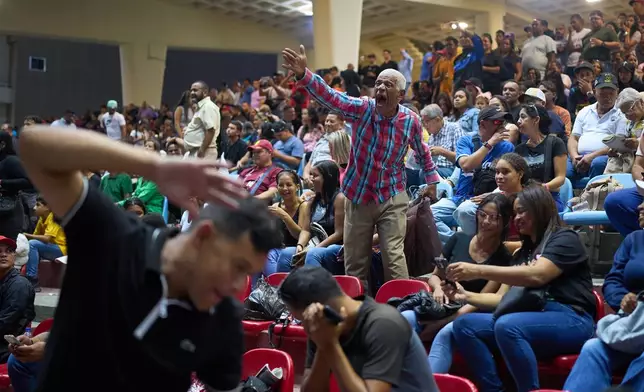 Spectators watch horse races during the 56th Jockey Challenge at the Rinconada racetrack in Caracas, Venezuela, Sunday, Dec. 14, 2025. (AP Photo/Arian Cubillos)