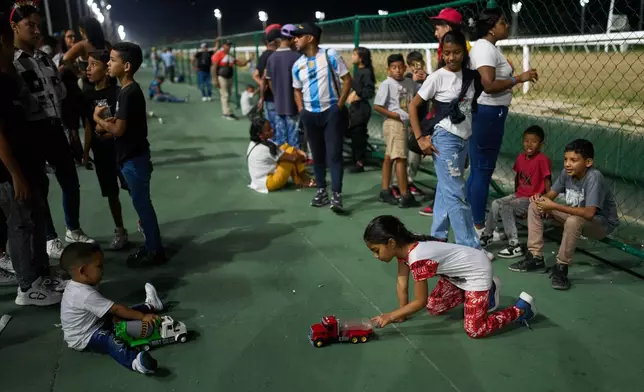 Children play during the 56th Jockey Challenge at the Rinconada racetrack in Caracas, Venezuela, Sunday, Dec. 14, 2025. (AP Photo/Arian Cubillos)