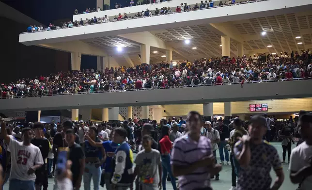 Spectators watch horse races during the 56th Jockey Challenge at the Rinconada racetrack in Caracas, Venezuela, Sunday, Dec. 14, 2025. (AP Photo/Arian Cubillos)