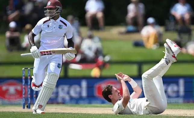 West Indies's Justin Greaves, left, takes a run as New Zealand's bowler Matt Henry falls to the ground on Day 4 of their cricket test match in Christchurch, New Zealand, Friday, Dec. 5, 2025. (Andrew Cornaga/Photosport via AP)