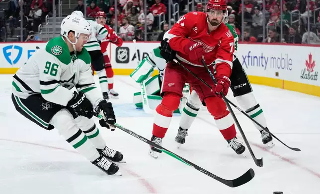 Detroit Red Wings center Dylan Larkin, right, moves the puck against Dallas Stars right wing Mikko Rantanen during the second period of an NHL hockey game Tuesday, Dec. 23, 2025, in Detroit. (AP Photo/Ryan Sun)