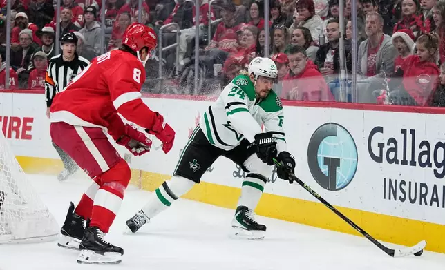 Dallas Stars center Roope Hintz, left, moves the puck against Detroit Red Wings defenseman Ben Chiarot during the first period of an NHL hockey game Tuesday, Dec. 23, 2025, in Detroit. (AP Photo/Ryan Sun)