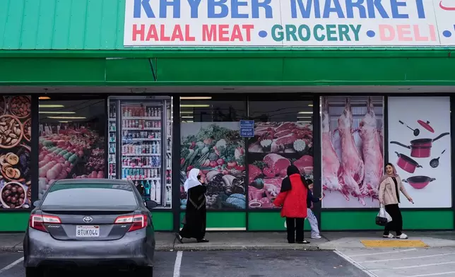 Women and children exit an Afghan grocery store in North Highlands, Calif., Friday, Dec. 5, 2025. (AP Photo/Godofredo A. Vásquez)