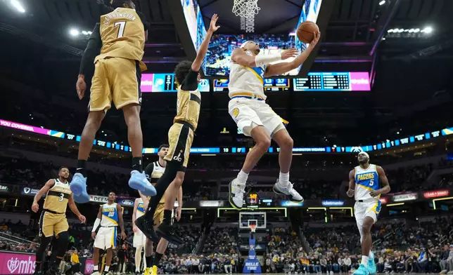 Indiana Pacers guard Andrew Nembhard, right, shoots in front of Washington Wizards guard Bub Carrington during the first half of an NBA basketball game in Indianapolis, Sunday, Dec. 14, 2025. (AP Photo/AJ Mast)