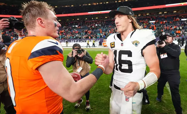 Denver Broncos quarterback Bo Nix, left, and Jacksonville Jaguars quarterback Trevor Lawrence (16) shake hands after an NFL football game in Denver, Sunday, Dec. 21, 2025. (AP Photo/Jack Dempsey)