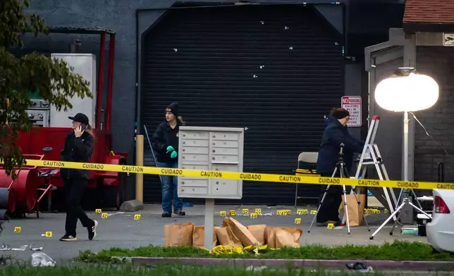Investigators examine the scene of a mass shooting Sunday, Nov. 30, 2025, in Stockton, Calif. (AP Photo/Ethan Swope)