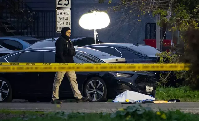 Investigators examine the scene of a mass shooting Sunday, Nov. 30, 2025, in Stockton, Calif. (AP Photo/Ethan Swope)