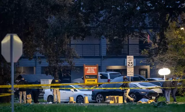 Investigators examine the scene of a mass shooting Sunday, Nov. 30, 2025, in Stockton, Calif. (AP Photo/Ethan Swope)
