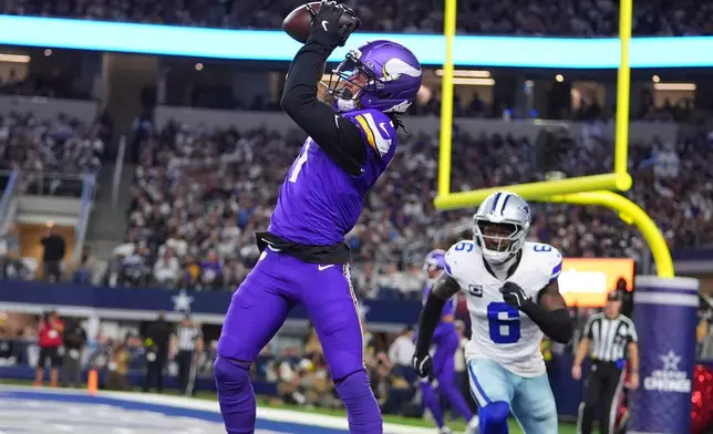 Minnesota Vikings wide receiver Jalen Nailor hauls in a touchdown catch in the end zone as Dallas Cowboys safety Donovan Wilson defends during the second half of an NFL football game Sunday, Dec. 14, 2025, in Arlington, Texas. (AP Photo/Julio Cortez)