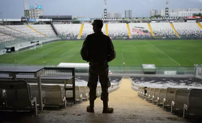 A soldier guards the National Stadium, where a polling station is set up beneath the stands, during the presidential runoff election in Santiago, Chile, Sunday, Dec. 14, 2025. (AP Photo/Natacha Pisarenko)