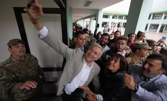 Jose Antonio Kast, presidential candidate for the Republican Party, takes a selfie after voting in the presidential runoff election in Santiago, Chile, Sunday, Dec. 14, 2025. (AP Photo/Esteban Felix)