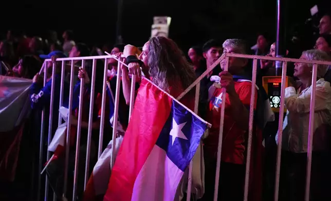 Supporters listen to Presidential candidate Jose Antonio Kast, of the opposition Republican Party, delivering his victory speech after winning the presidential runoff election in Santiago, Chile, Sunday, Dec. 14, 2025. (AP Photo/Natacha Pisarenko)