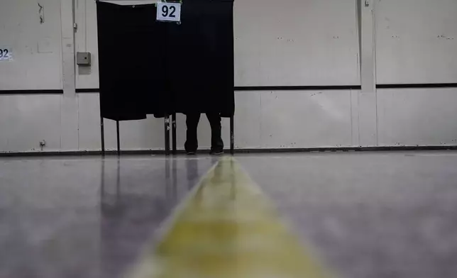 A voter marks their ballot during the presidential runoff election in Santiago, Chile, Sunday, Dec. 14, 2025. (AP Photo/Matias Delacroix)