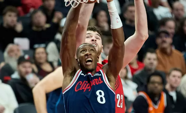 Los Angeles Clippers guard Kris Dunn (8) shoots in front of Portland Trail Blazers center Donovan Clingan during the second half of an NBA basketball game in Portland, Ore., Friday, Dec. 26, 2025. (AP Photo/Craig Mitchelldyer)