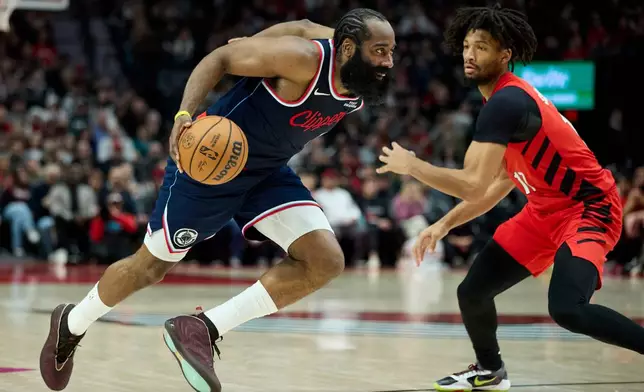 Los Angeles Clippers guard James Harden, left, dribbles past Portland Trail Blazers guard Shaedon Sharpe during the second half of an NBA basketball game in Portland, Ore., Friday, Dec. 26, 2025. (AP Photo/Craig Mitchelldyer)