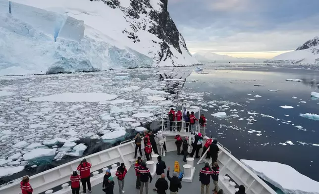 Passengers watch as a ship sails through the Lemaire Channel in Antarctica, Monday, Nov. 24, 2025. (AP Photo/Mark Baker)