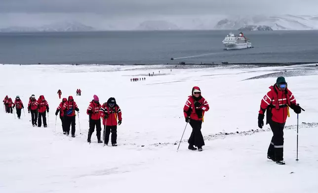 Passengers walk inside the volcano at Deception Island in Antarctica, Wednesday, Nov. 26, 2025. (AP Photo/Mark Baker)