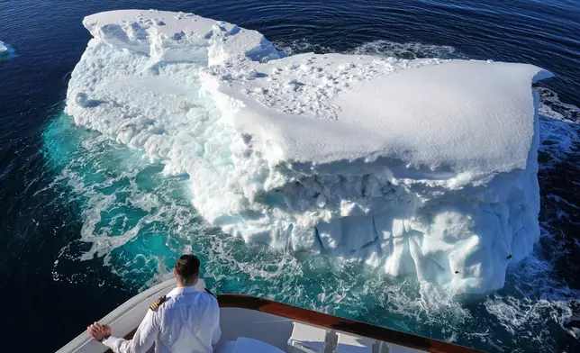 A member of the ship's crew looks at an iceberg near Yalour Islands in Antarctica, Monday, Nov. 24, 2025. (AP Photo/Mark Baker)