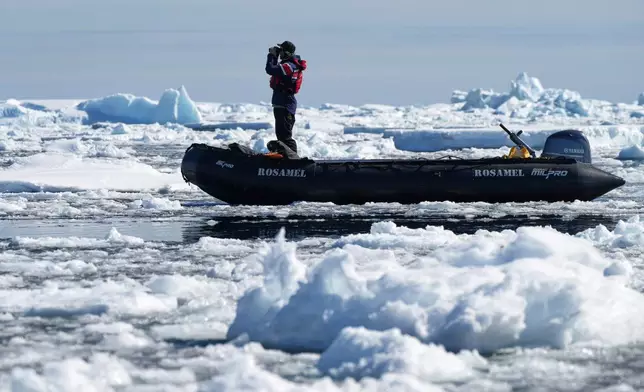 A crew member looks for whales at Yalour Islands in Antarctica, Monday, Nov. 24, 2025. (AP Photo/Mark Baker)