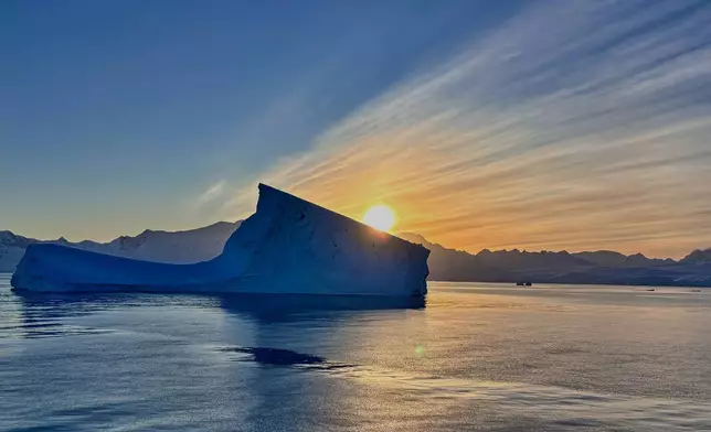 The sun sets near a iceberg in Antarctica, Friday, Nov. 21, 2025. (AP Photo/Mark Baker)